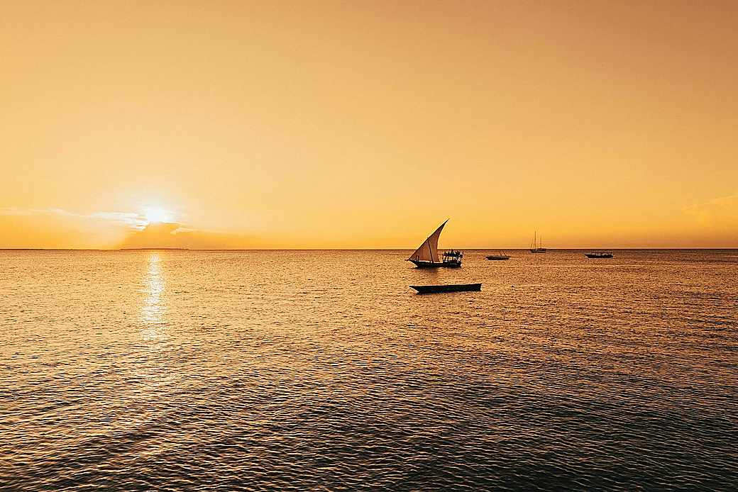 A dhow sailing at sunset off Zanzibar